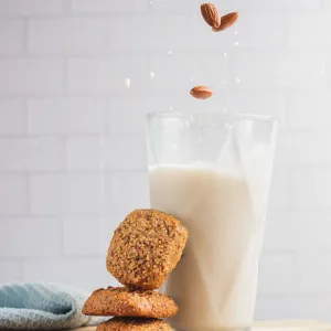 A milk and some cookies on the table.