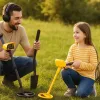 A family is using an adult metal detector and a kids metal detector to hunt treasure.