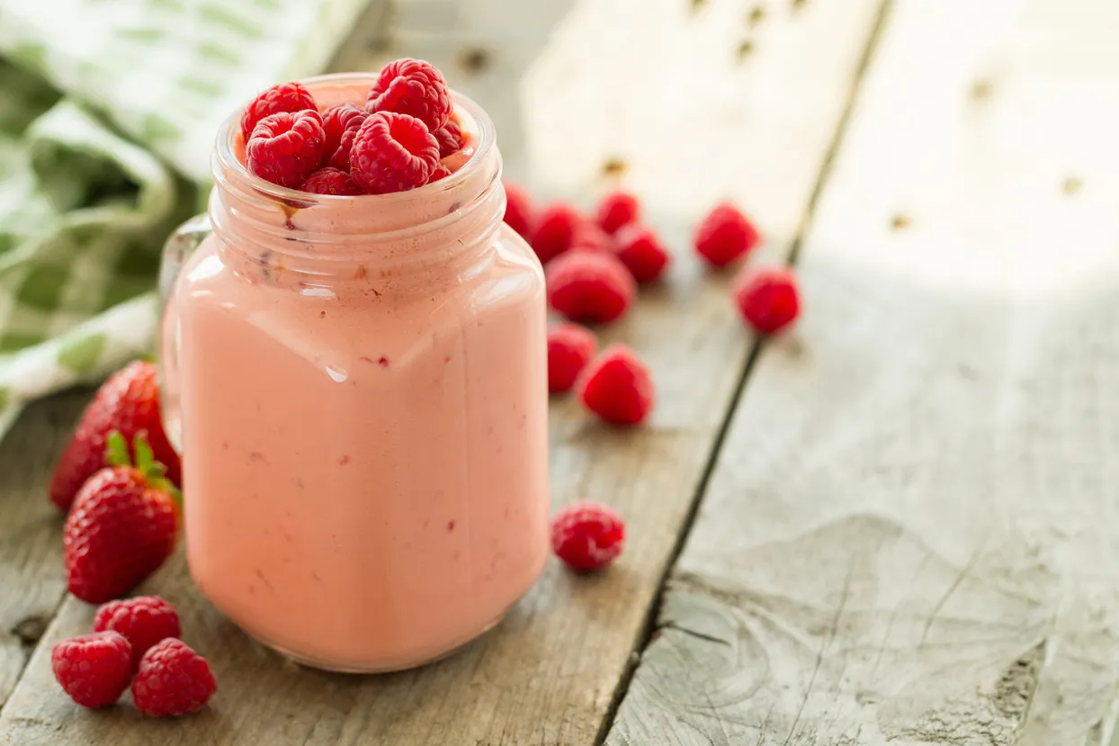 A glass of raspberry shake on the table.