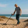 A man is hunting treasure by metal detector.
