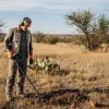 A man is using metal detector to hunt treasure in Texas.