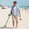 A man is detecting treasure on beach in Florida.