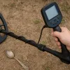 A man is using metal detector to detect treasure.