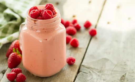 A glass of raspberry shake on the table.