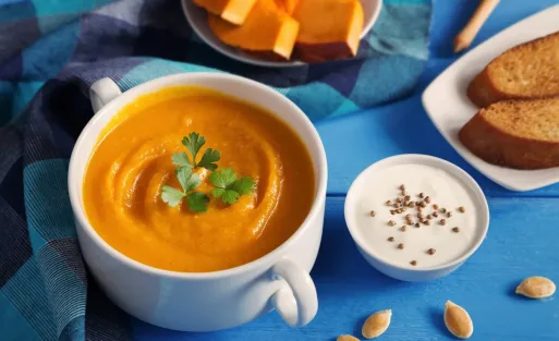 A cup of pumpkin and a nutmilk with blue background.