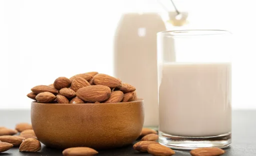 Two cups of milk and a pan of nut are on the table.